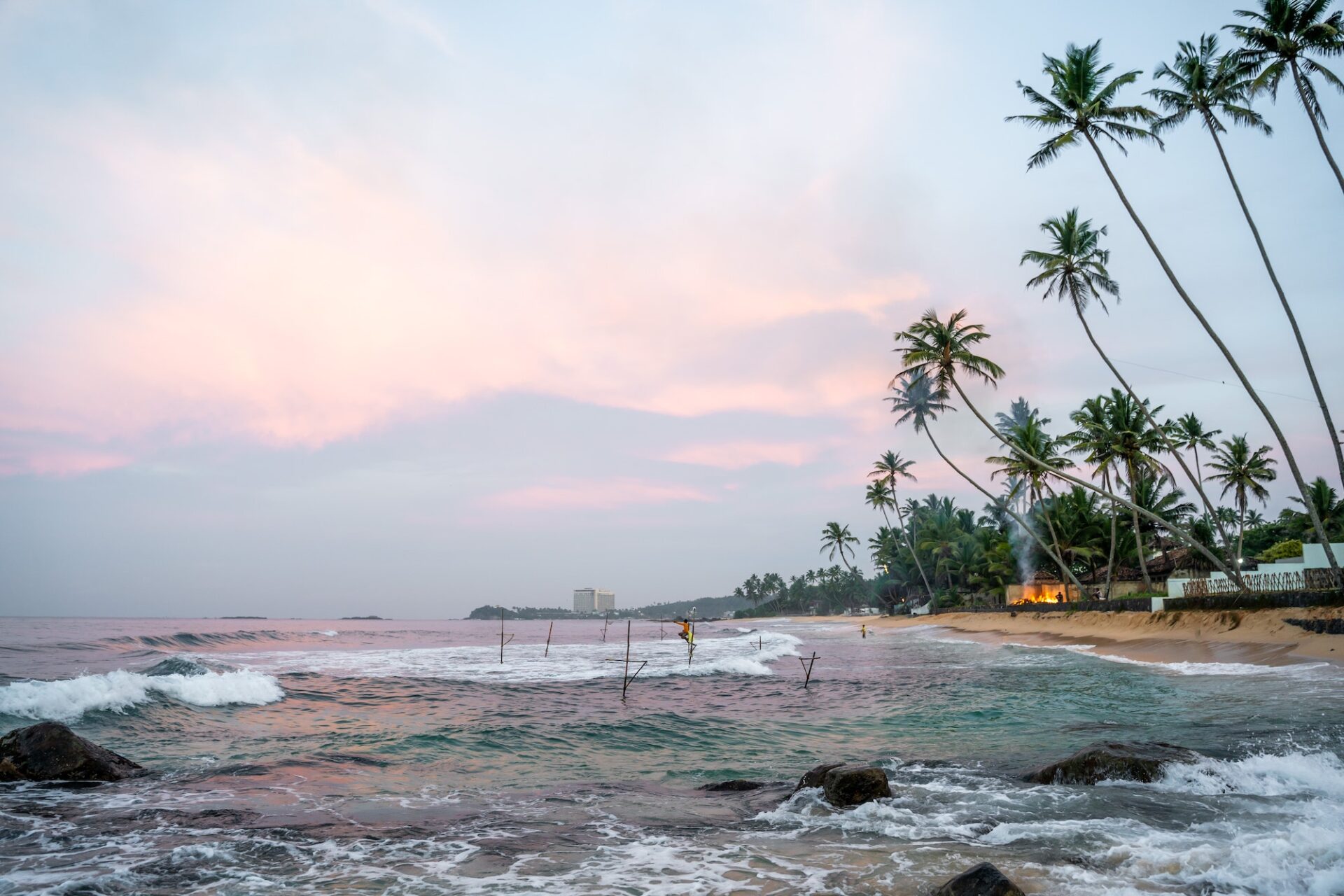 Sunrise with fishermen in Unawatuna, Sri Lanka, beach, palm trees and ocean
